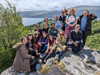 Group of people sitting on a rock and posing for a group photo
