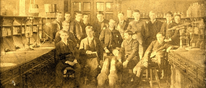 Old sepia photograph of a group belonging to the School of Chemistry in a lab