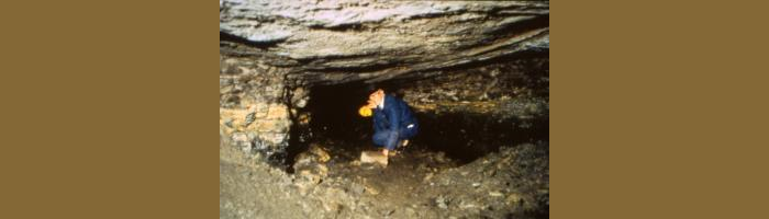 Person crouching inside the old mine under the Chemistry building