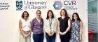 A group of five people standing in front of a wall with logos and text. The logos include the University of Glasgow, CVR Centre for Virus Research, and Medical Research Council.