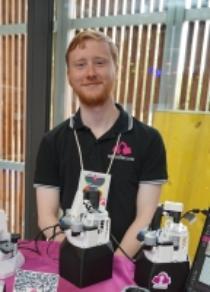 Picture of Ben Chisholm with an OpenFlexure microscope.