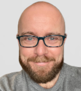 A head and shoulders portrait shot of Chris Finlay, set against a plain grey background