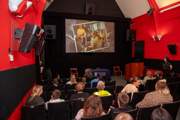 People sitting in Gilmorehill Halls cinema watching a movie
