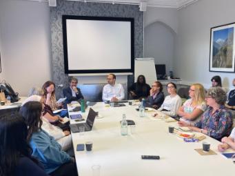 Session participants sharing ideas round a rectangular conference table