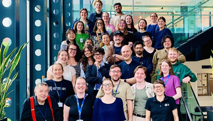Participants and organisers from the 2025 Strathclyde Optical Microscopy Course (SOMC) stood together on steps in a modern building