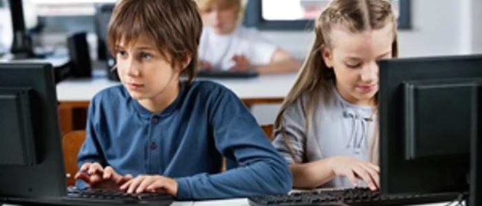 Two children using desktop computers