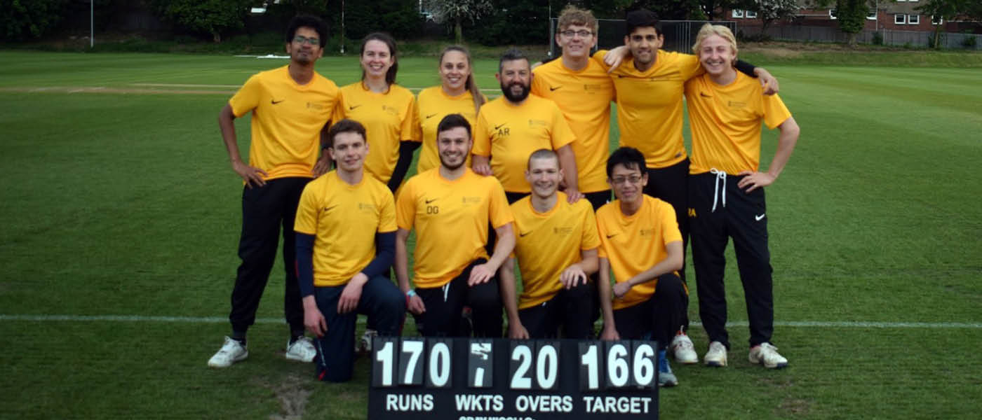 Cricket club huddled together around scoreboard
