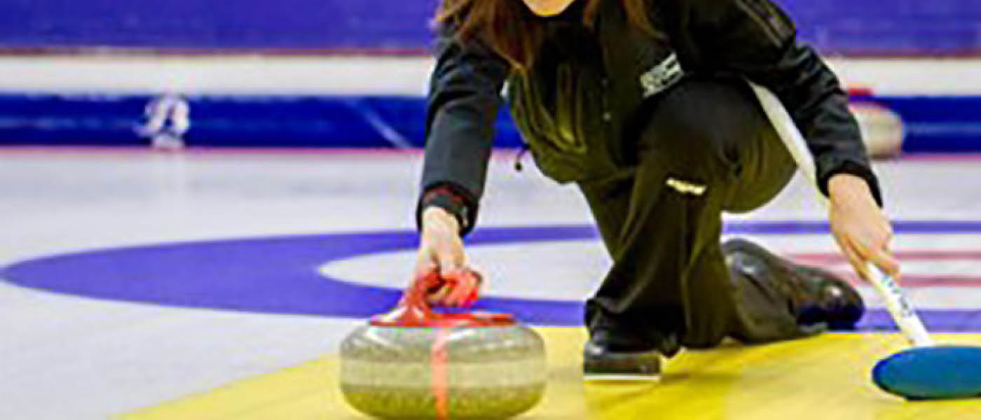 Someone curling on an ice rink