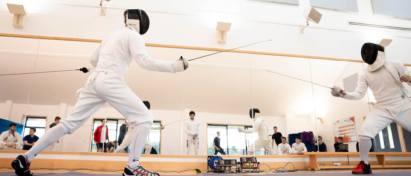 Two student competing in fencing