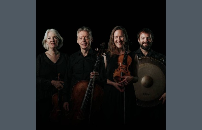 Four musicians from the Hebrides Ensemble standing in a line, holding instruments.
