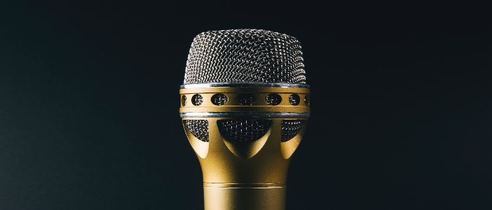 A gold microphone against a black background