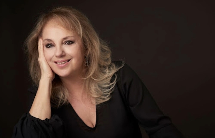 Photo of Haydee Schvartz leaning on her hand, looking away from the camera and smiling