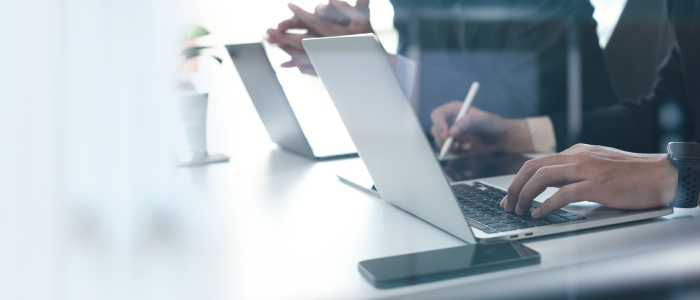 Two businessmen having a discussion, working on laptop computer, using digital tablet and mobile phone during meeting at office. Business planning and solution, working together concept
