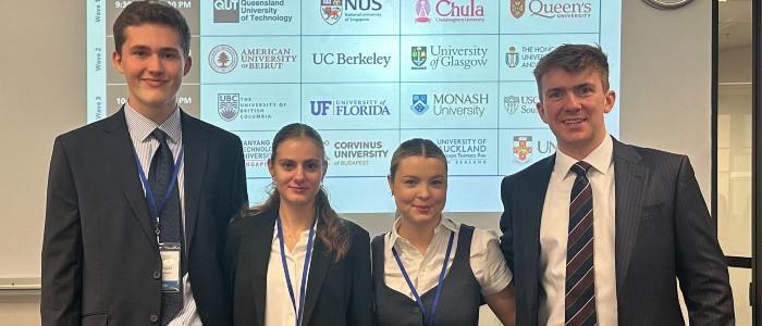 4 students standing in front of a screen