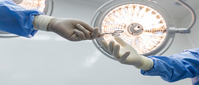 Surgeons hand each other an instrument
