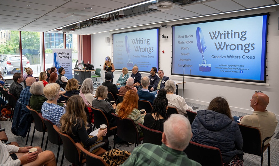 Audience is listening to a speaker with Writing Wrongs on the screens