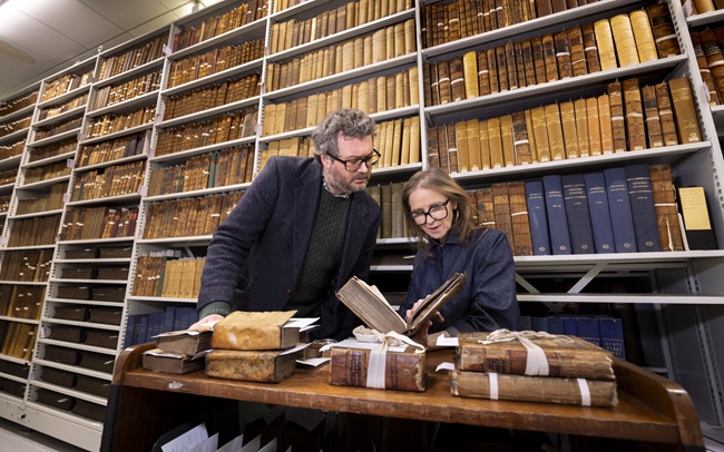 Professor Adrian Streeteand  and Siobhán Convery, Director, Library Collections, look at a dictionary from the personal library of Zachary Boyd. Credit Martin Shields.