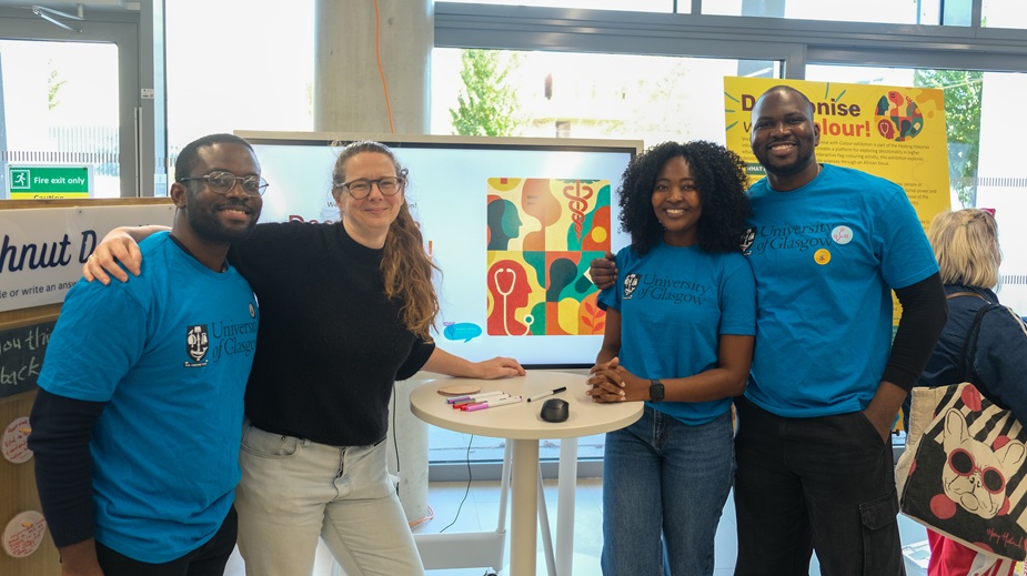 Four students standing in front of a screen in Byres Hub