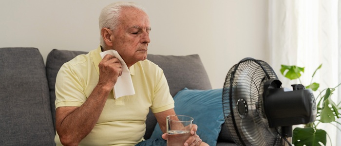 An older man tries to cool himself