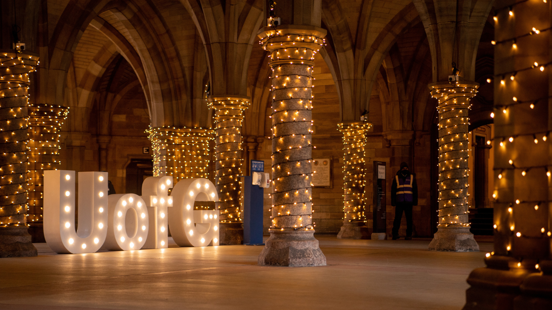 University Cloisters in the evening with fairy lights and a large white U of G letters