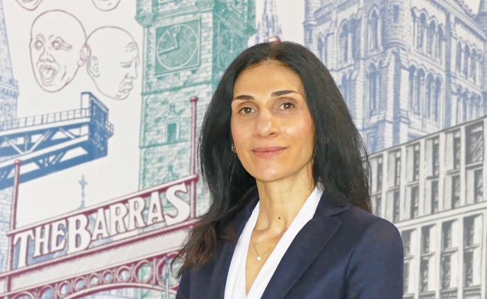 Dr Paulina Navrouzoglou profile photo in front of the wall mural in the Adam Smith Building, University of Glasgow