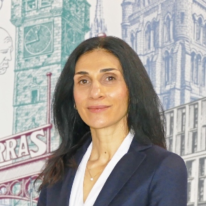 Paulina Navrouzoglou standing in front of a wall mural at the University of Glasgow Adam Smith Business School