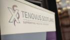 The Tenovus Scotland logo on a plaque that is pictured at an angle