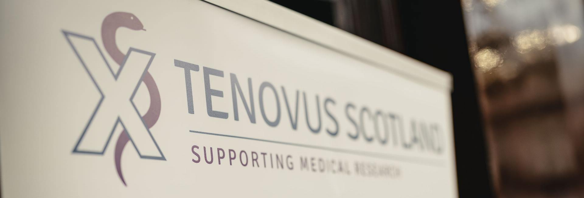 The Tenovus Scotland logo on a plaque that is pictured at an angle