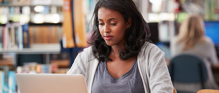 Image of student using a laptop in library