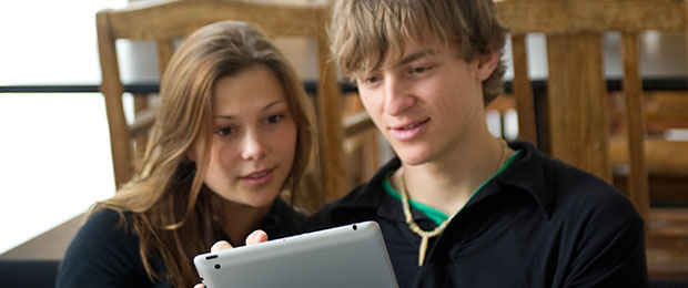 male and female student looking at a tablet computer