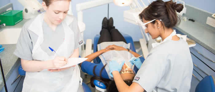 horizontal banner - 2 students working on a patient
