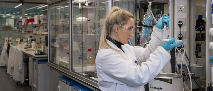 S student researcher working in a lab with equipment