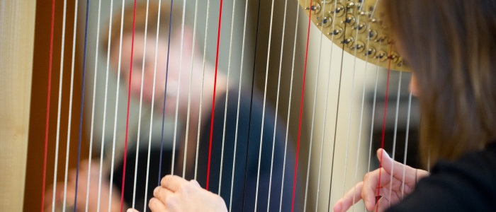 Music student playing harp