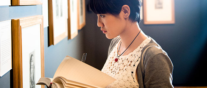 Art history student with book in a gallery