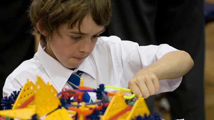 A school pupil concentrating on his K'nex model