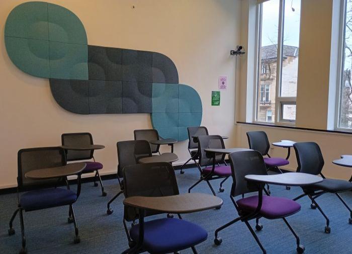 Flat floored teaching room with tablet chairs.