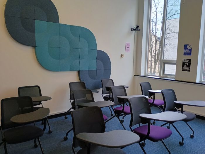 Flat floored teaching room with tablet chairs.