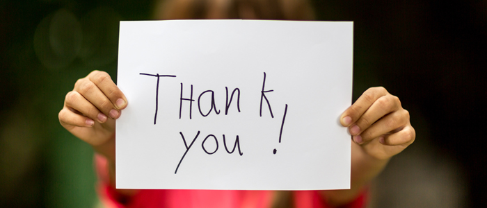 child holding thank you sign