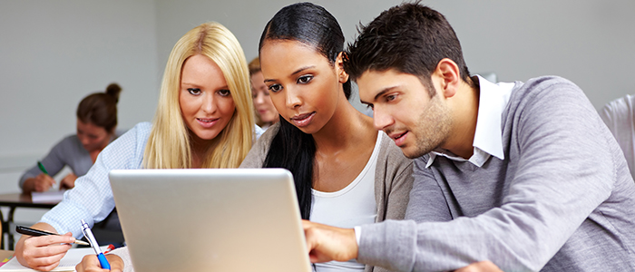 Image of students seated at a laptop