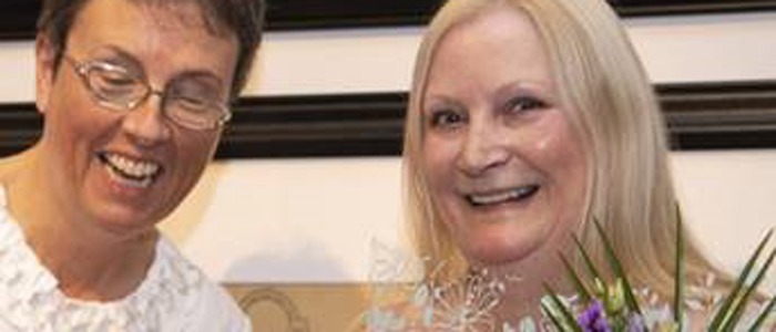 Photo of Professor Anna Cooper being presented with flowers by Professor Jill Pell on the occasion of her retirement