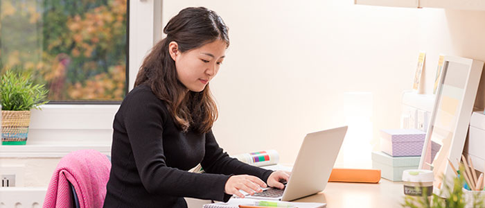 Image of student woking on laptop in accommodation