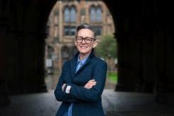Photograph of Dr Amanda Sykes.  She is wearing glasses, smiling towards the camera and has her arms folded