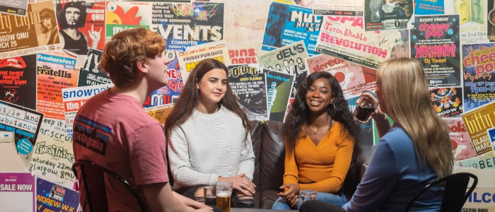 Group of students sitting chatting in Jim's Bar, Queen Margaret Union