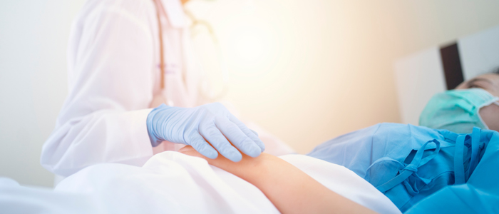 Photo of COVID-10 patient being comforted by healthcare professional