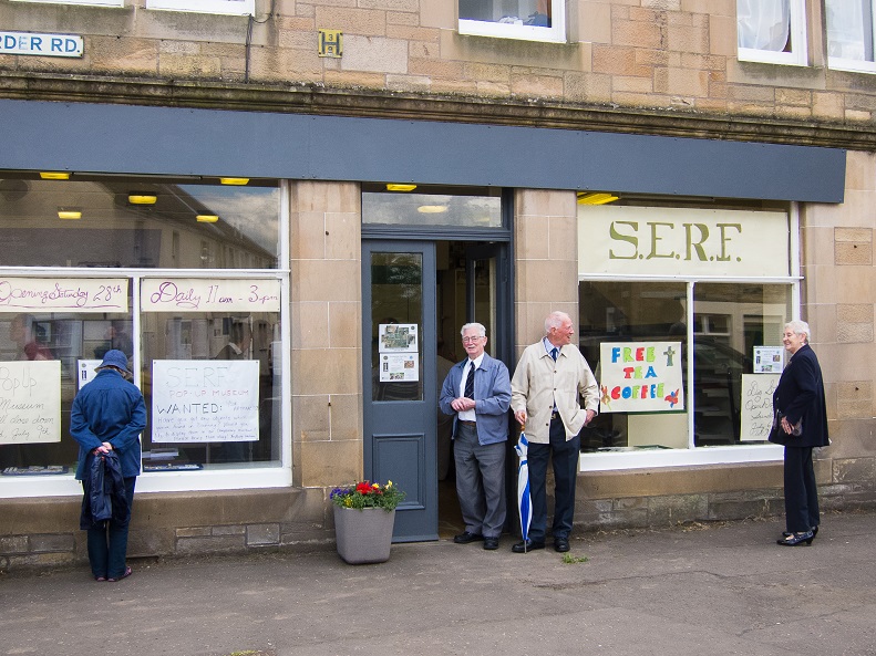 Four community members stand outside storefront housing the SERF pop-up museum in Dunning in 2012.