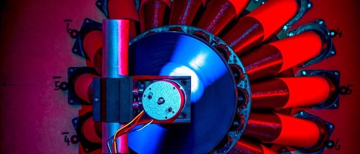 A photograph of the experimental setup for the 'twisted sound' experiment showing the ring of speakers