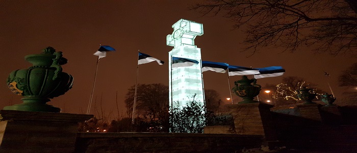 Monument with flags flying beside it