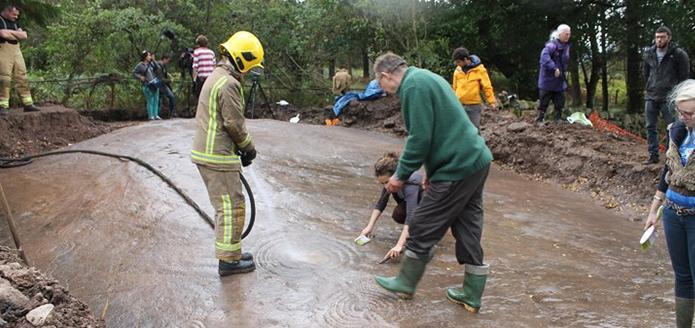 A cropped version of firefighters cleaning the Cochno stone.