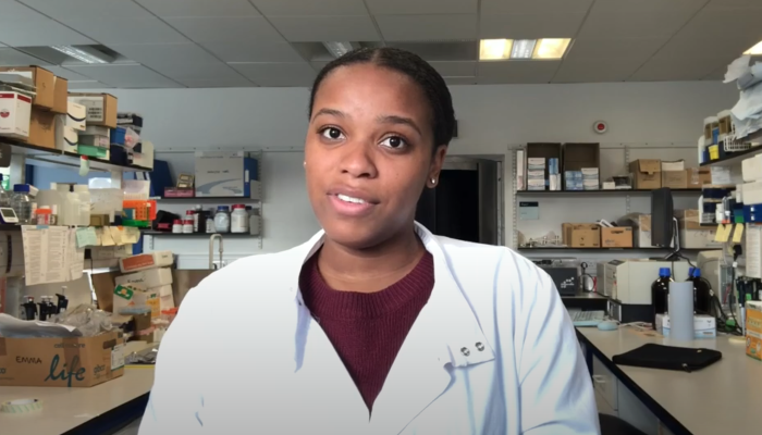 PhD student Kristyn Carter in the lab addressing the camera for a Black History Month UK 2020 vlog