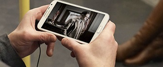 Hands holding mobile, watching movie on the underground